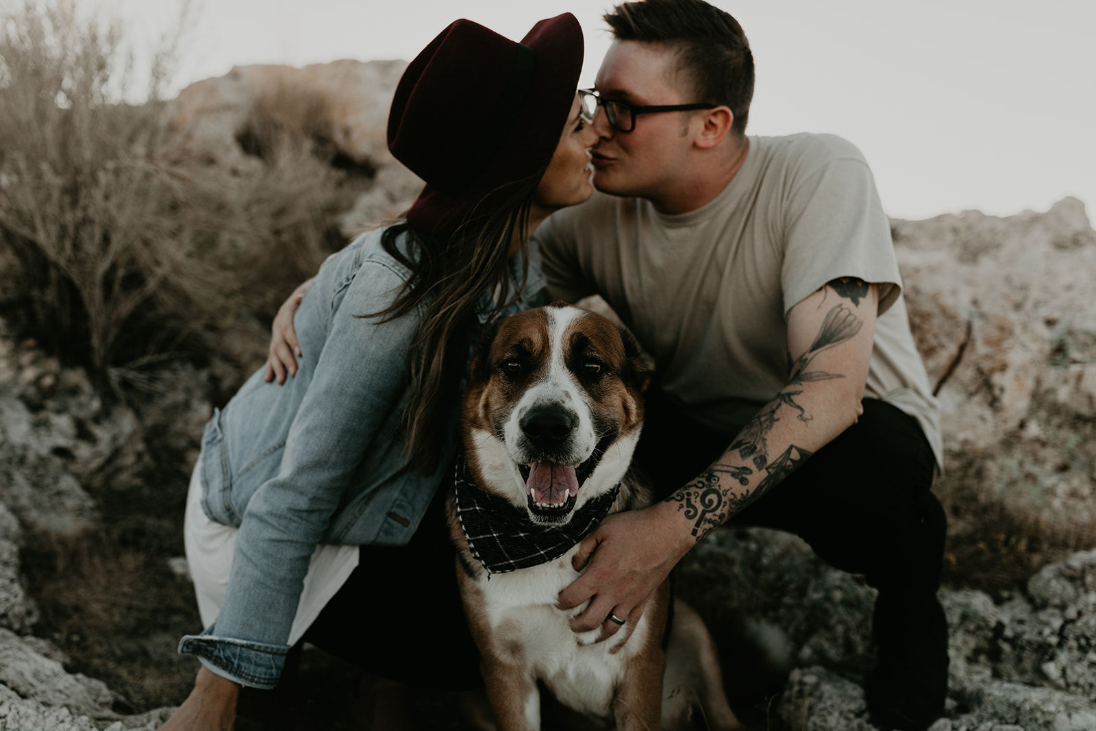 couple pose together with their dog on rocks in the beautiful Utah nature during their Engagement photos in Utah