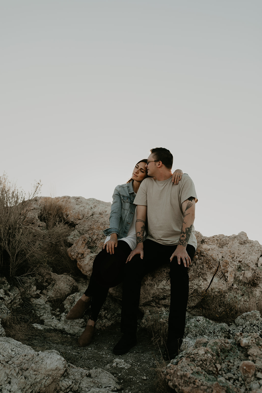 couple sit together on rocks 