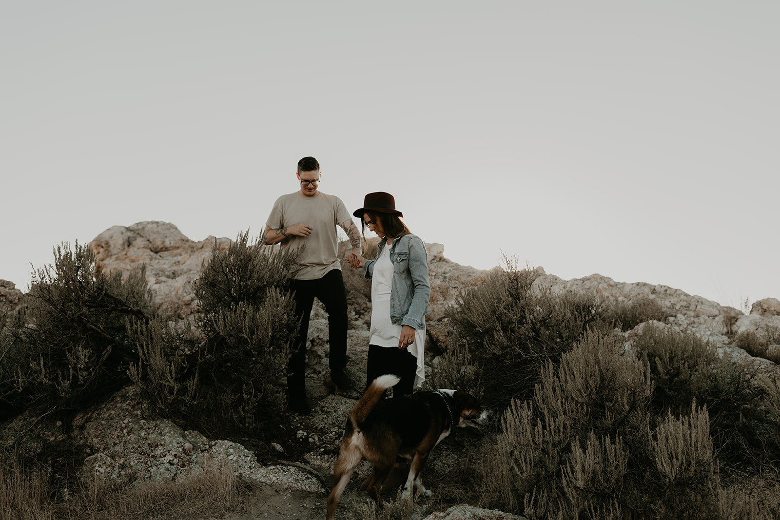 couple pose together with their dog on rocks in the beautiful Utah nature during their Engagement photos in Utah