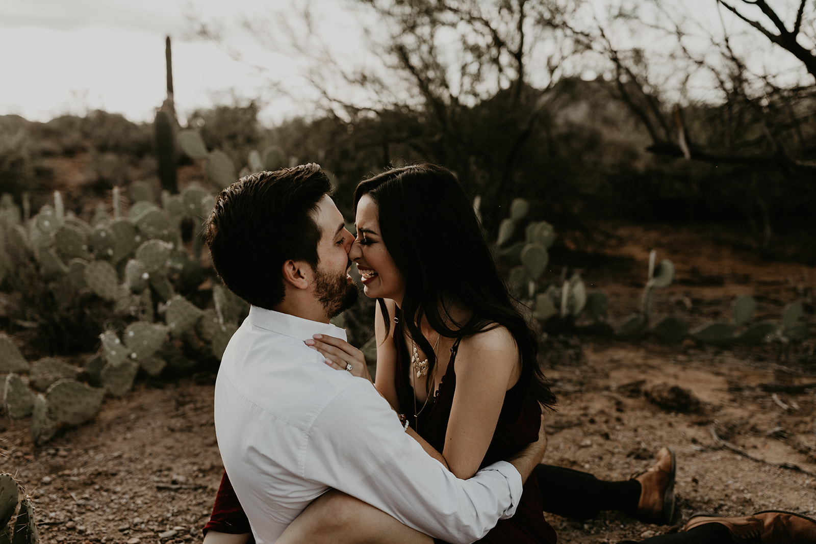 a couple share a laugh while sitting in the Arizona desert