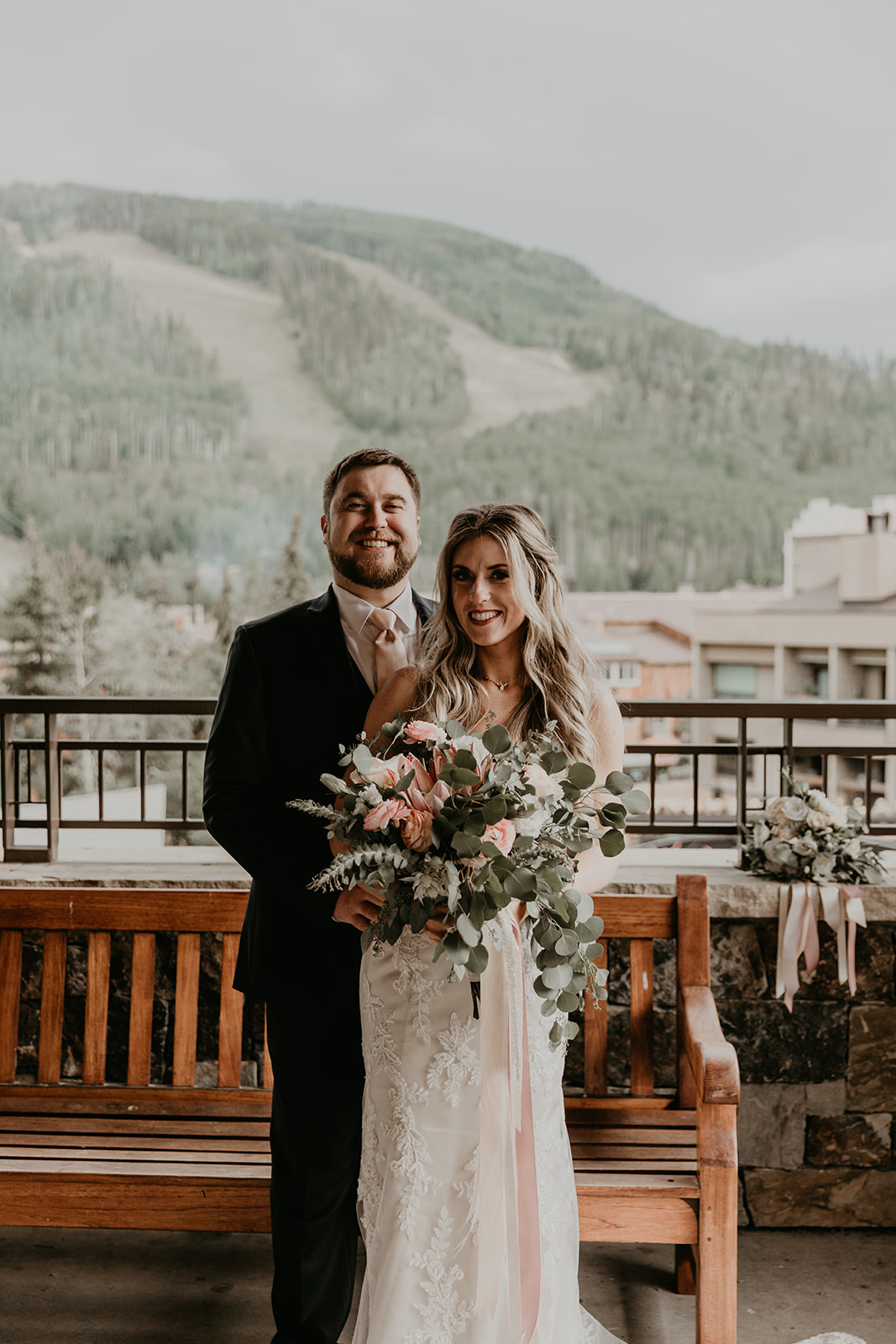 bride and groom pose with the Colorado ski slopes in the background