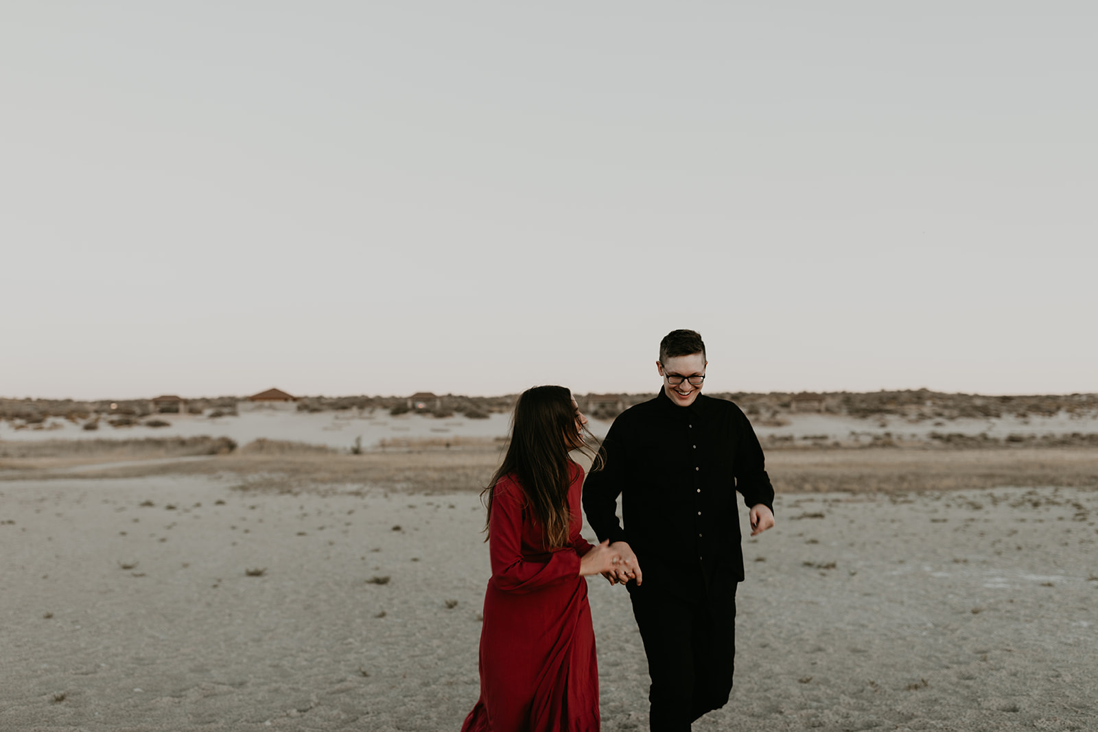 beautiful couple walk through the desert flats 