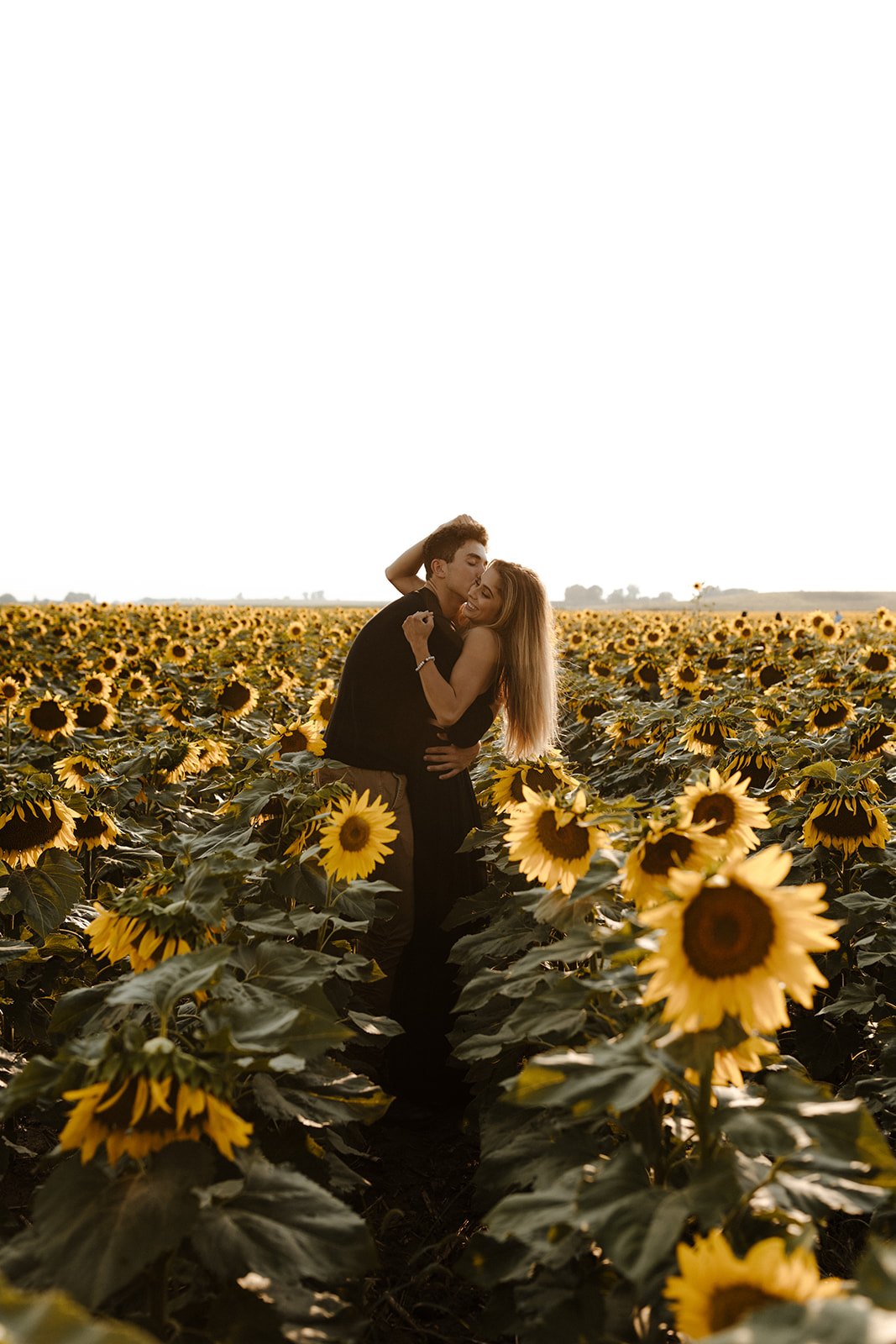 stunning couple pose for a romantic photo during their Denver sunflower field engagement session 