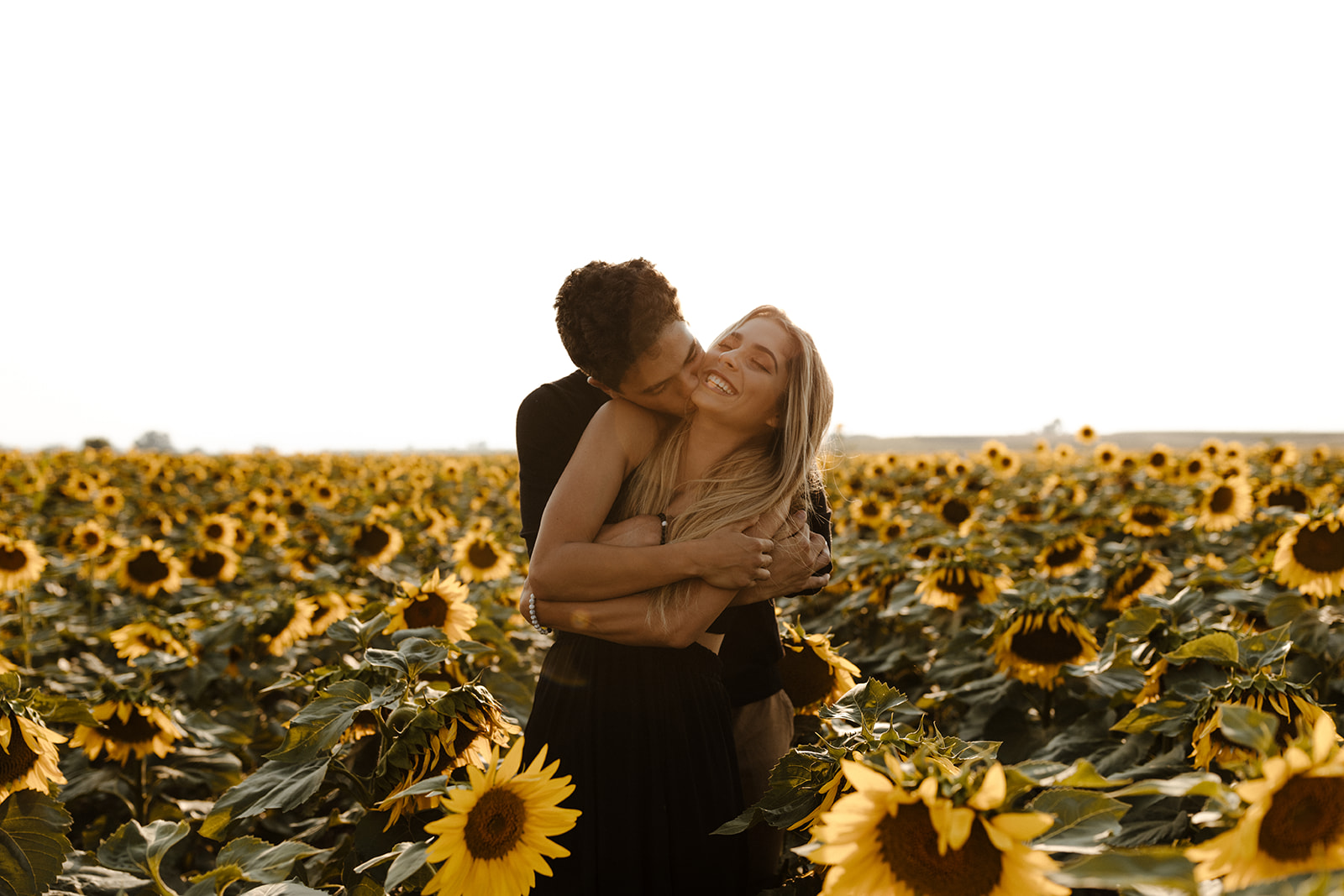 stunning couple pose for a romantic photo during their Denver sunflower field engagement session 