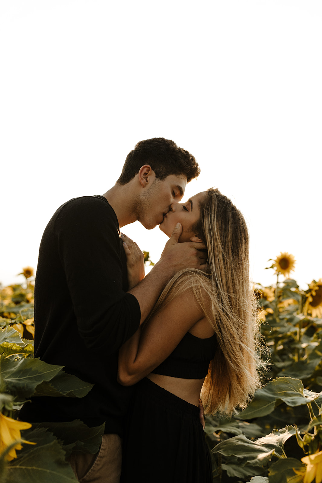 stunning couple share a kiss during their Denver sunflower field engagement session 