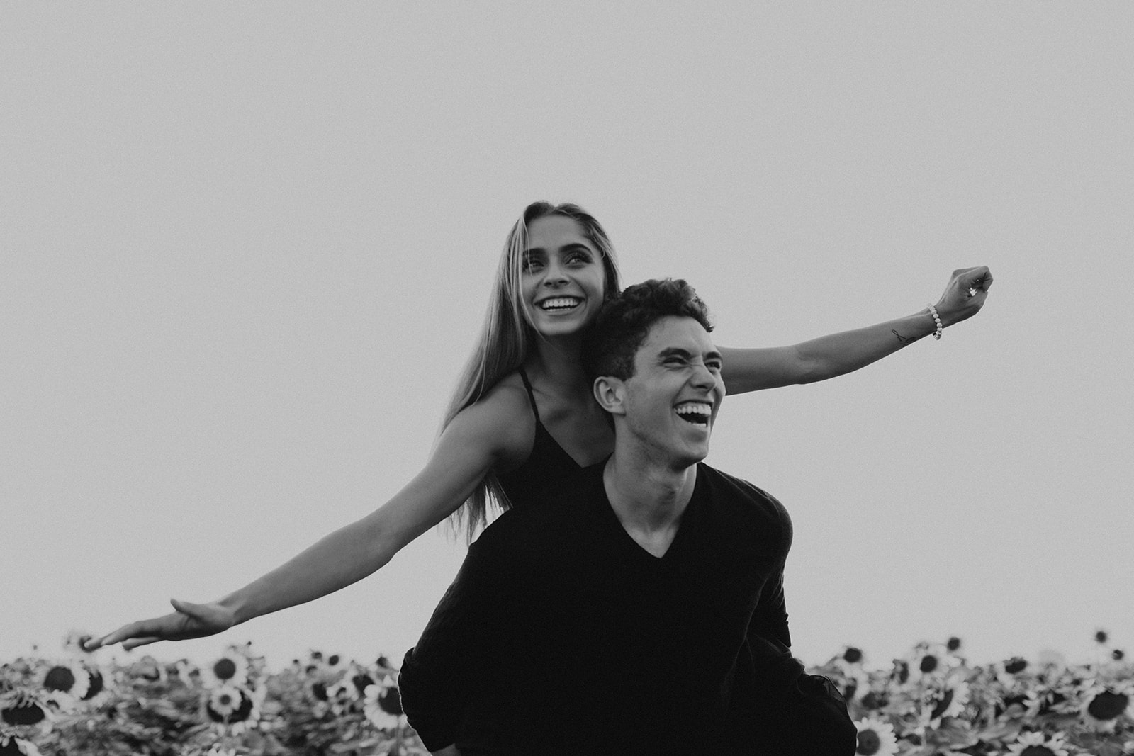 couple pose candidly during their dreamy Denver sunflower field engagement photoshoot