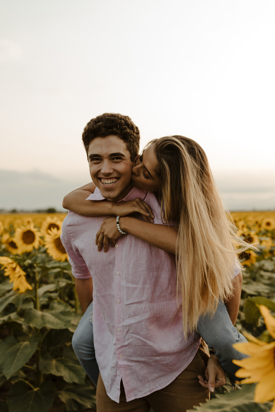 stunning couple share a kiss during their Denver sunflower field engagement session 