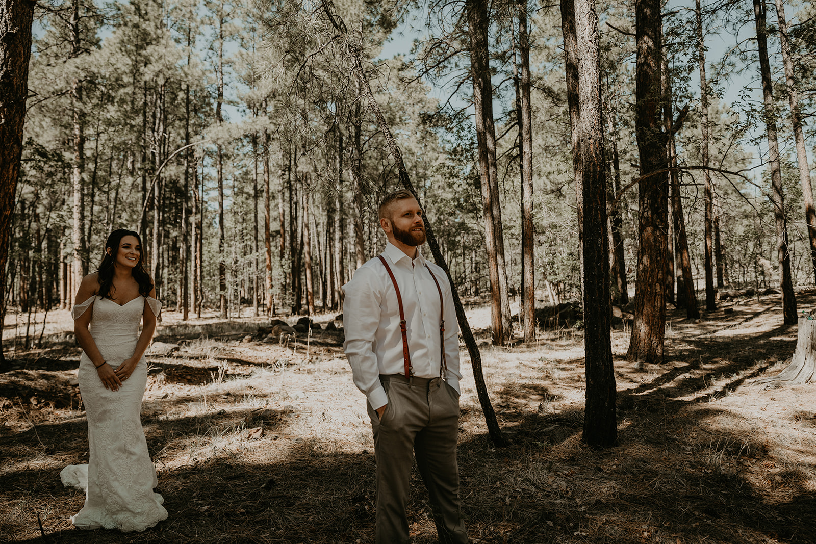 bride waits to surprise her soon to be husband during their first look wedding photos