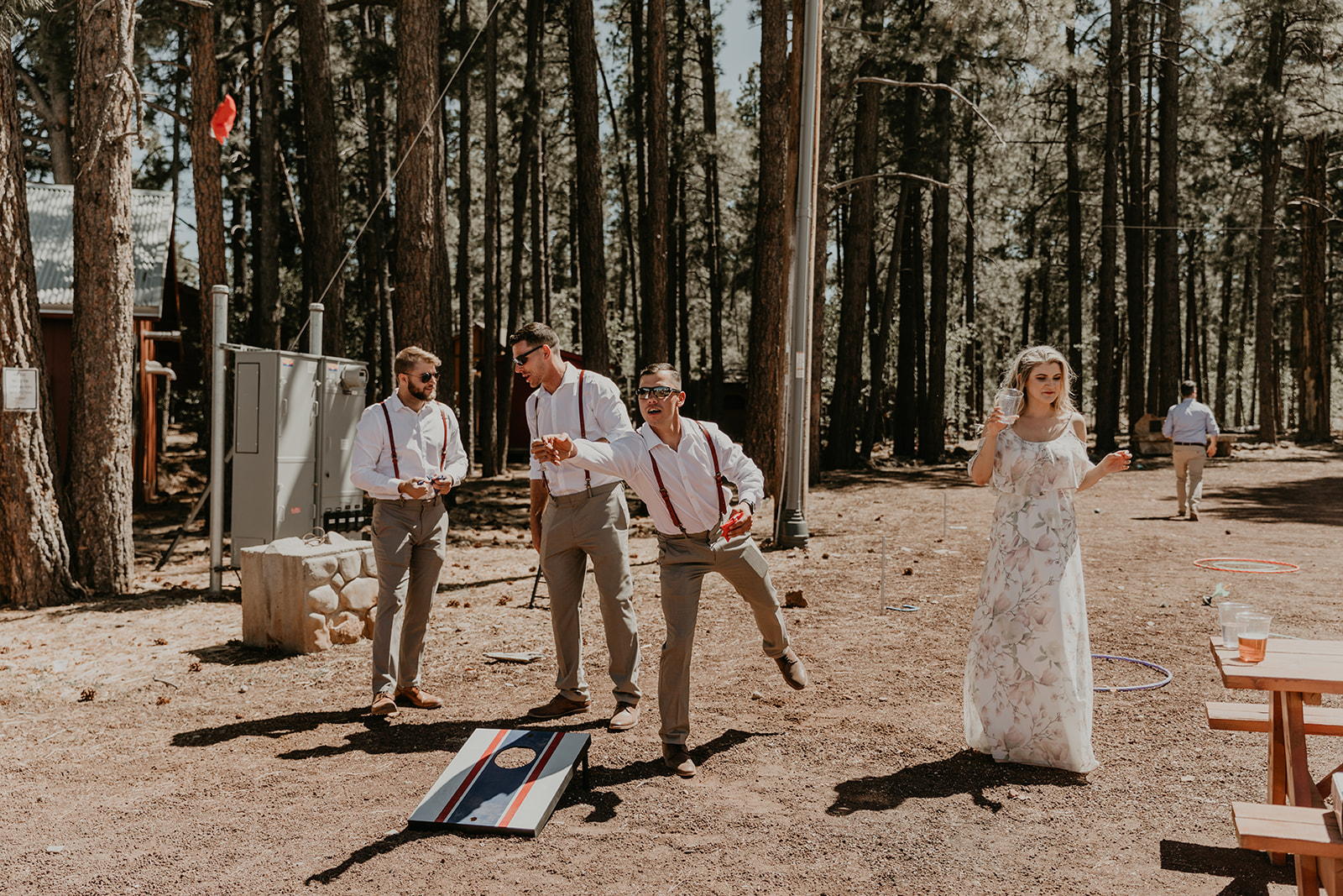 groomsmen play cornhole outside of the dreamy Mormon lake lodge wedding reception 