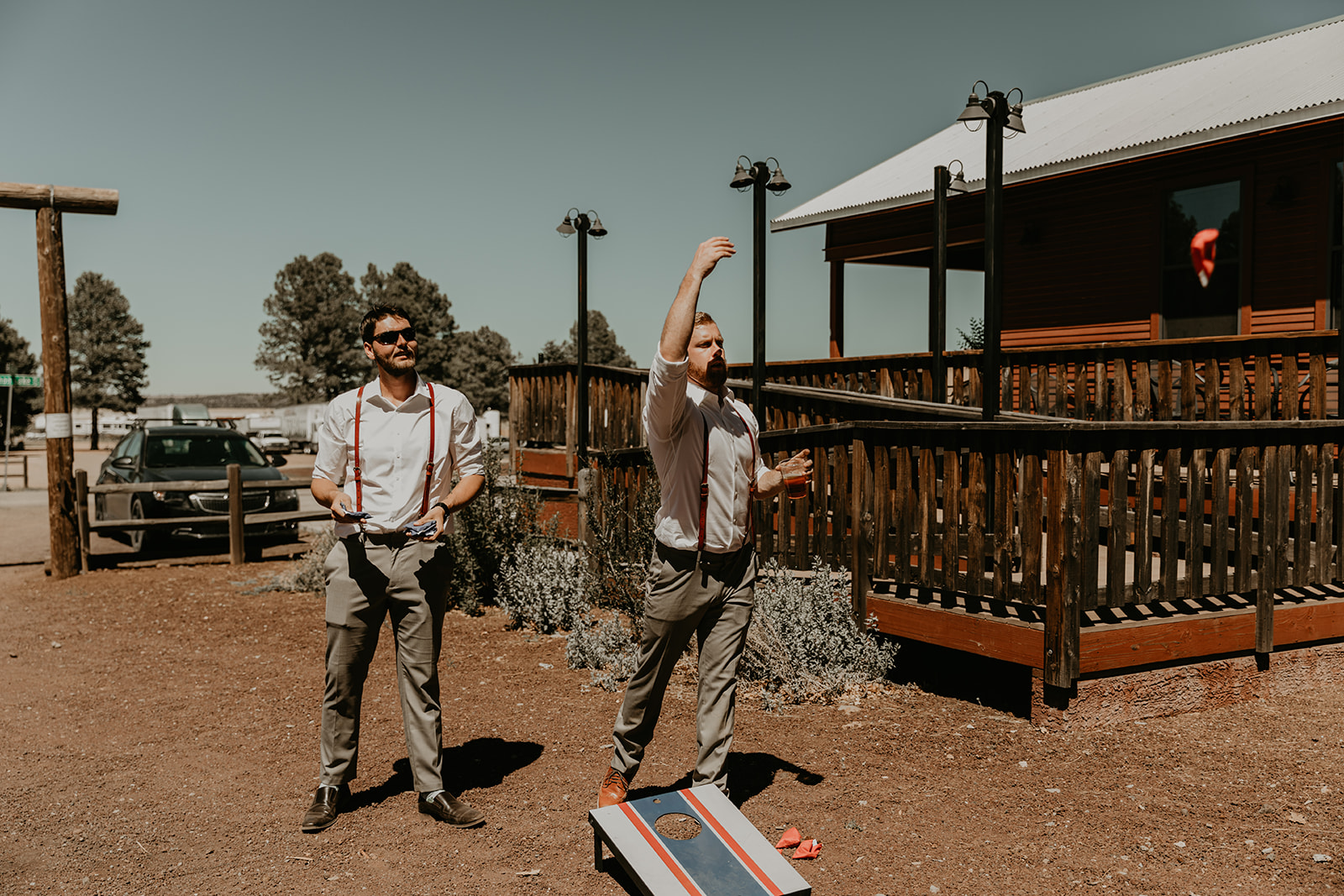 groomsmen play cornhole outside of the dreamy Mormon lake lodge wedding reception 