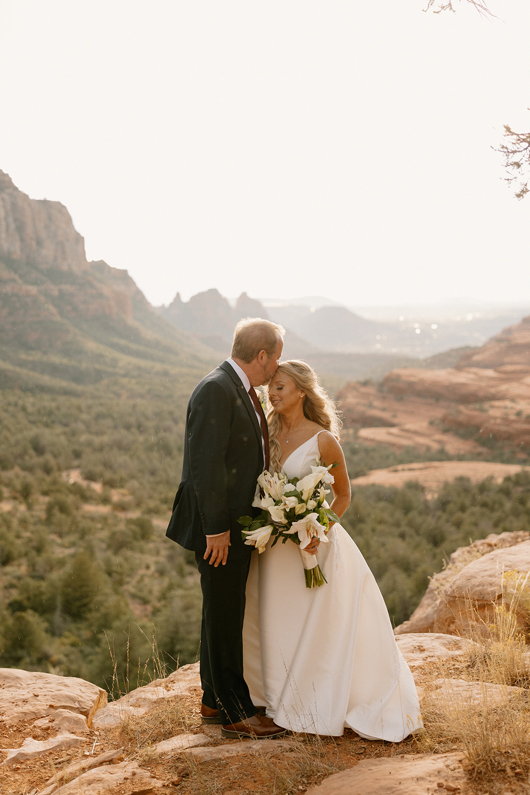 bride and groom pose with the Arizona canyon in the background