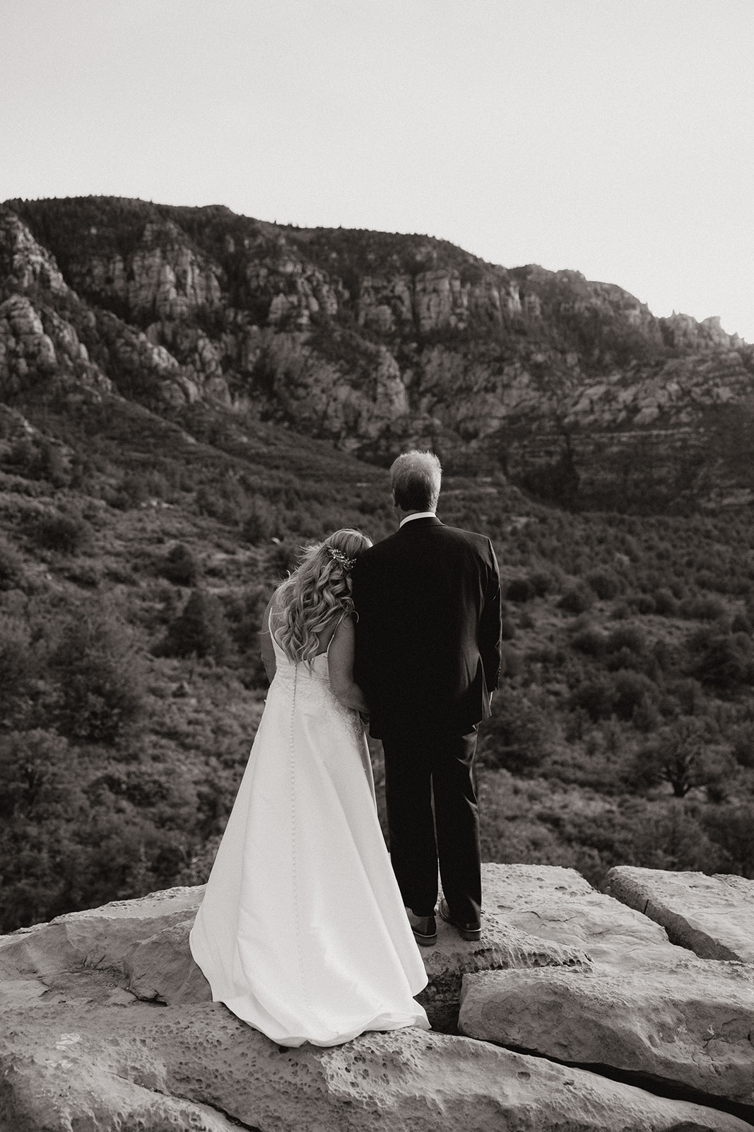 bride and groom pose with the Arizona canyon in the background