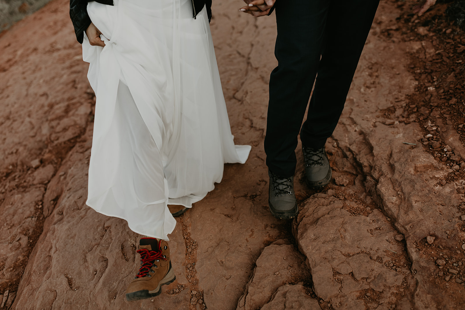 couple climb the rocks towards the summit 