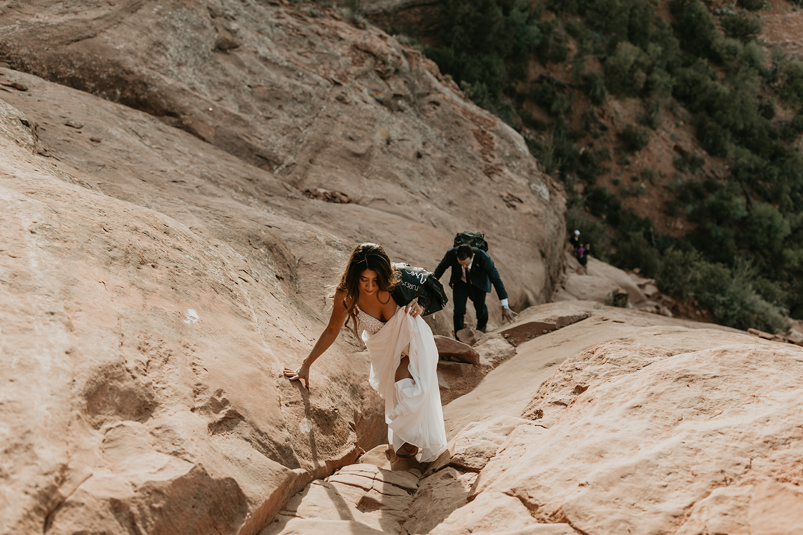 couple climb the rocks towards the summit 