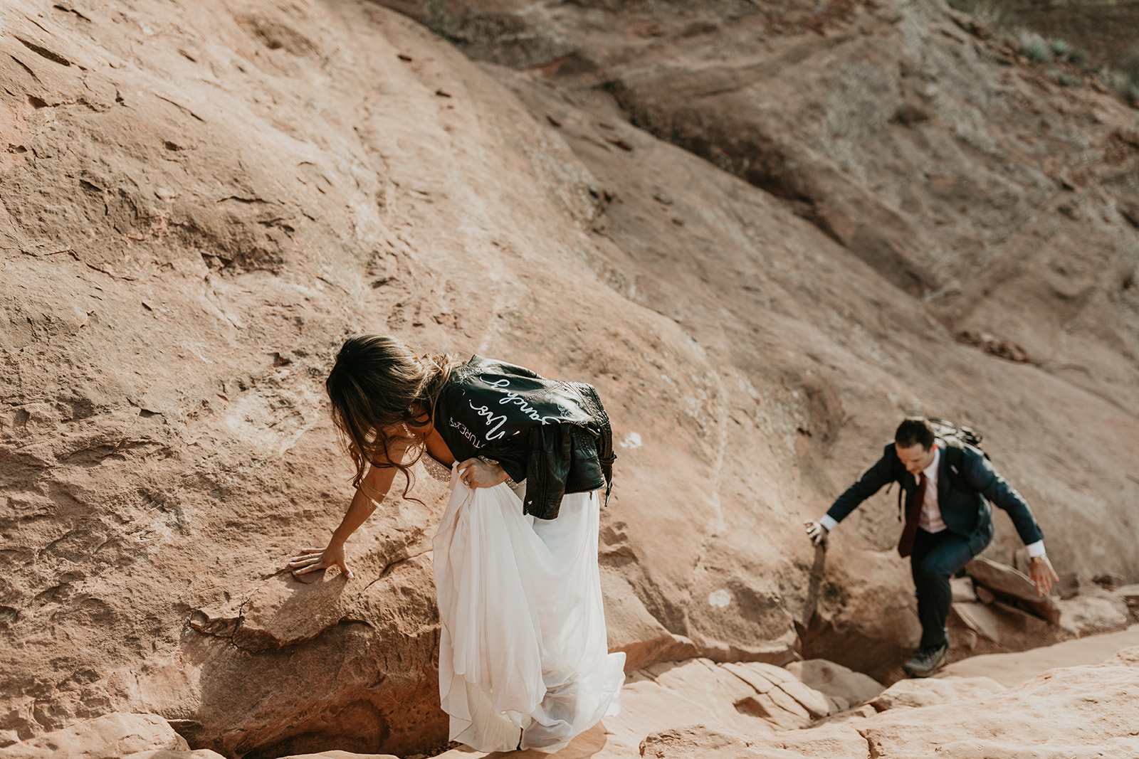 couple climb the rocks towards the summit 