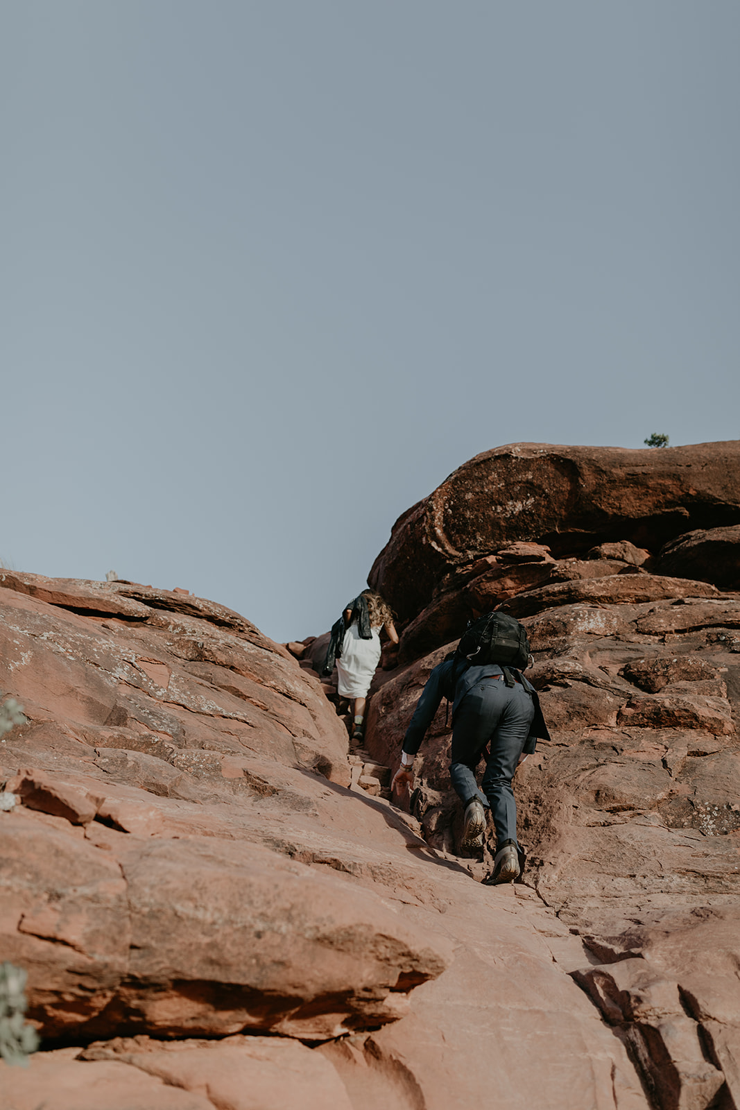 couple climb the rocks towards the summit 