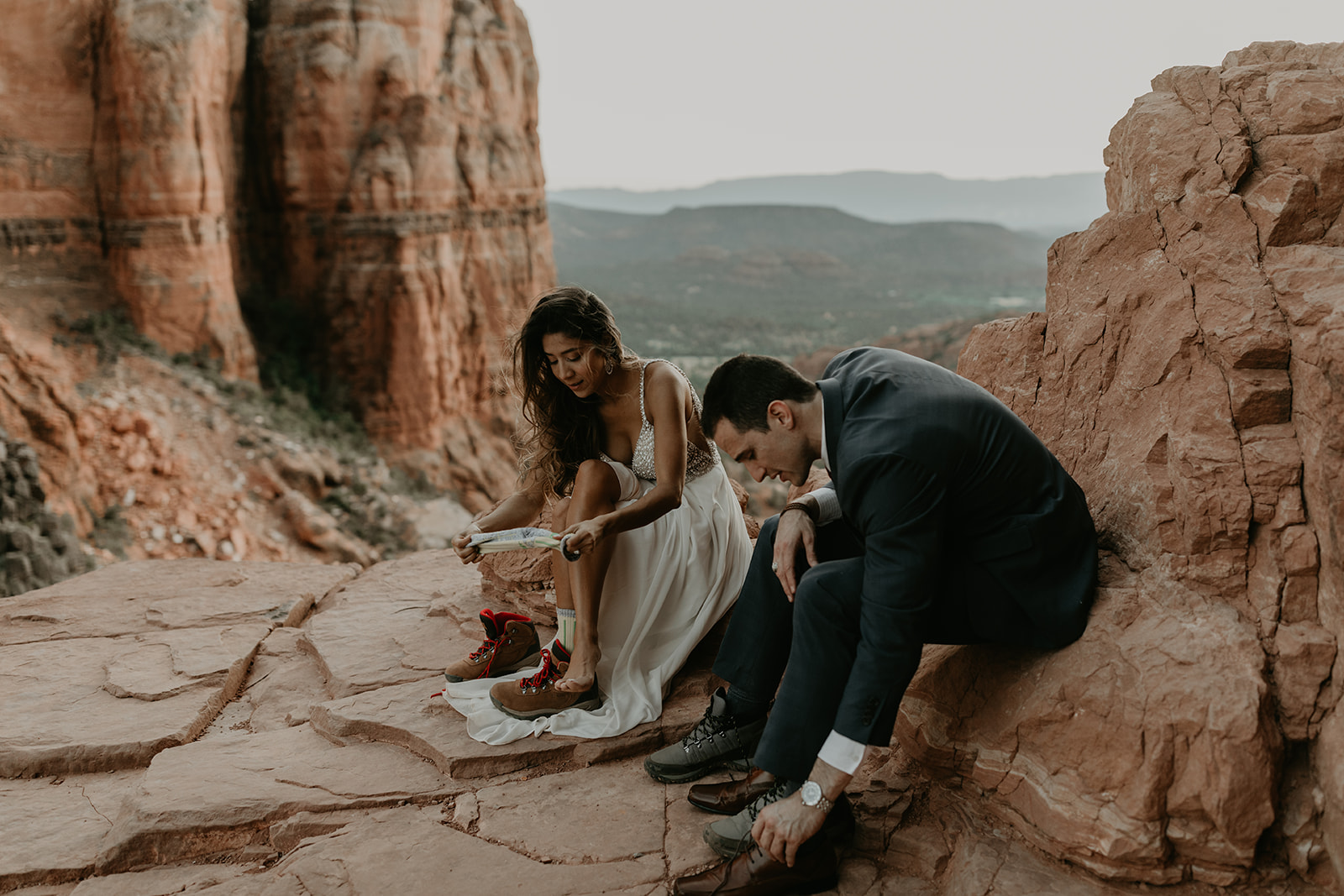 stunning couple change their shoes after their hike to Cathedral rock in the Arizona desert! 