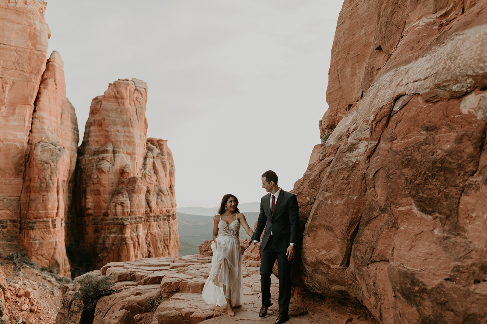 stunning couple stand in the red rocks of the Arizona desert