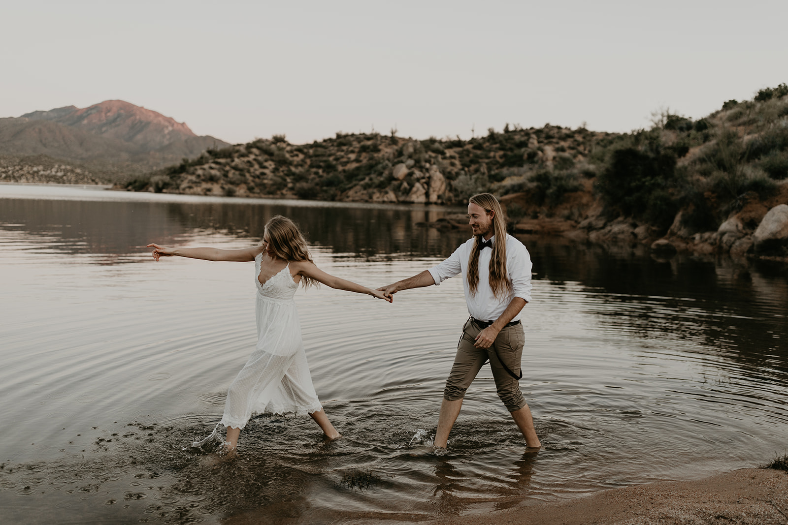 stunning couple play in Bartlett Lake during their Arizona engagement photoshoot