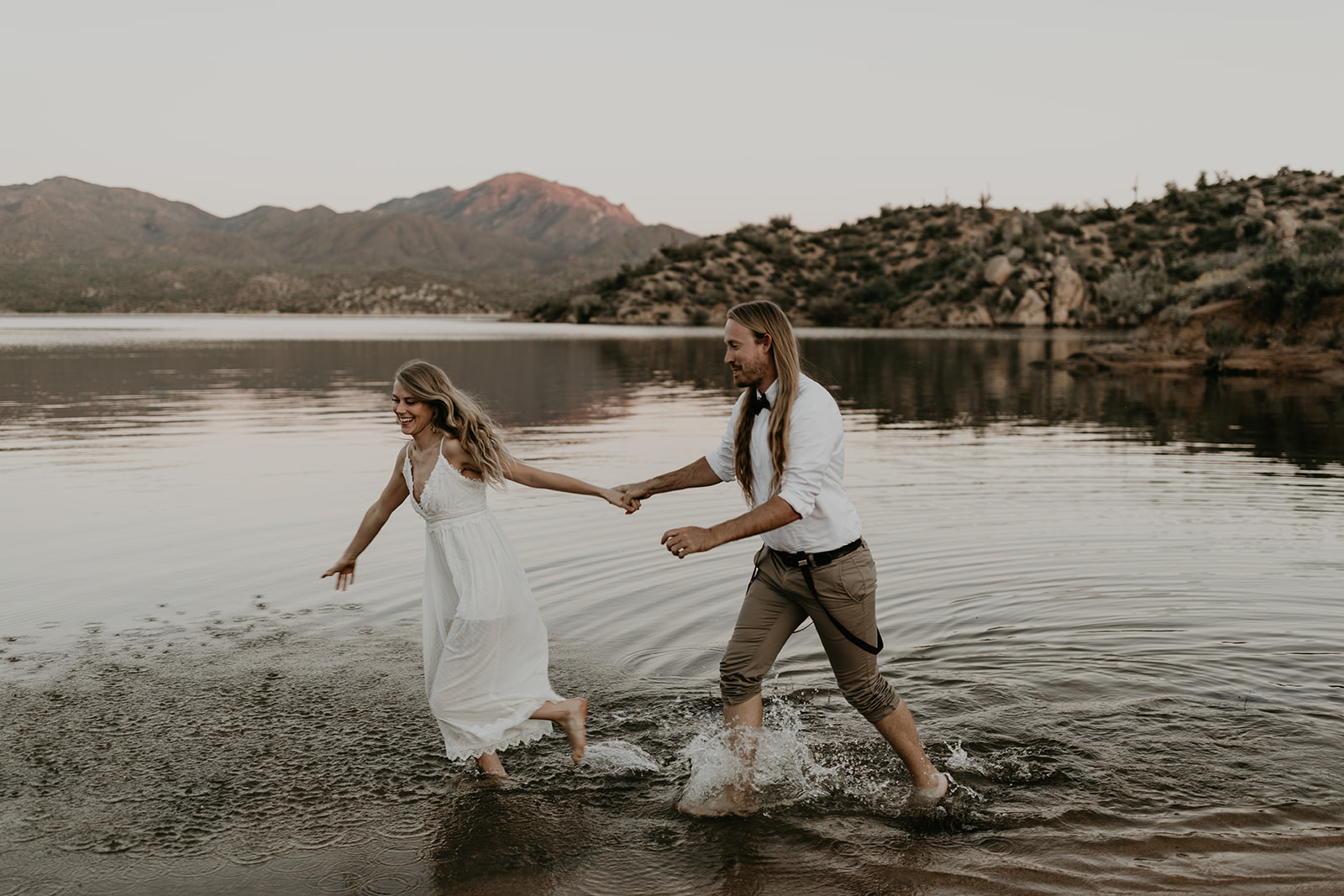 stunning couple play in Bartlett Lake during their Arizona engagement photoshoot