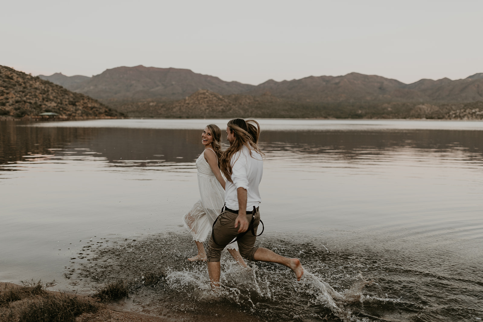 stunning couple play in Bartlett Lake during their Arizona engagement photoshoot