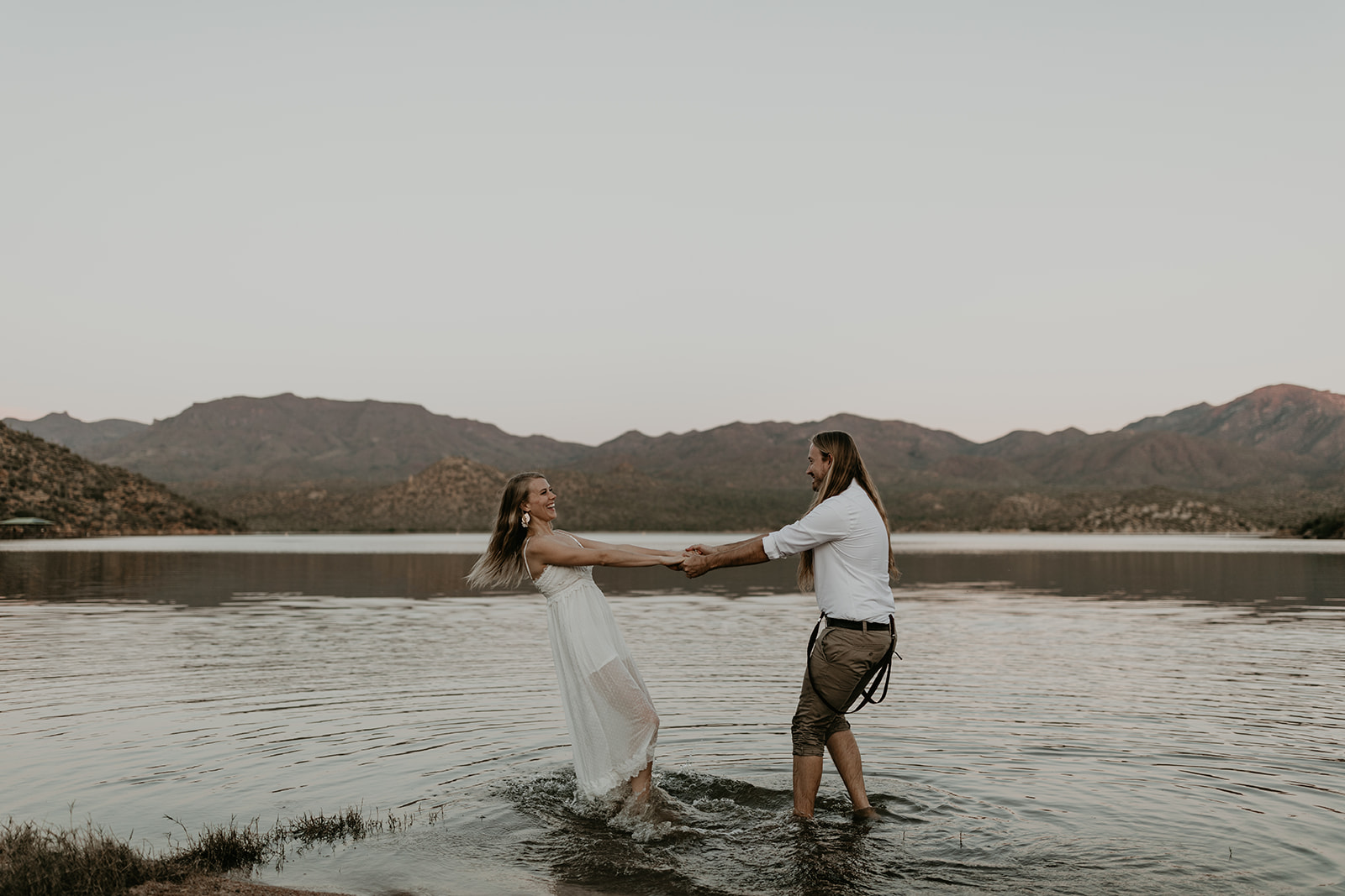 stunning couple play in Bartlett Lake during their Arizona engagement photoshoot