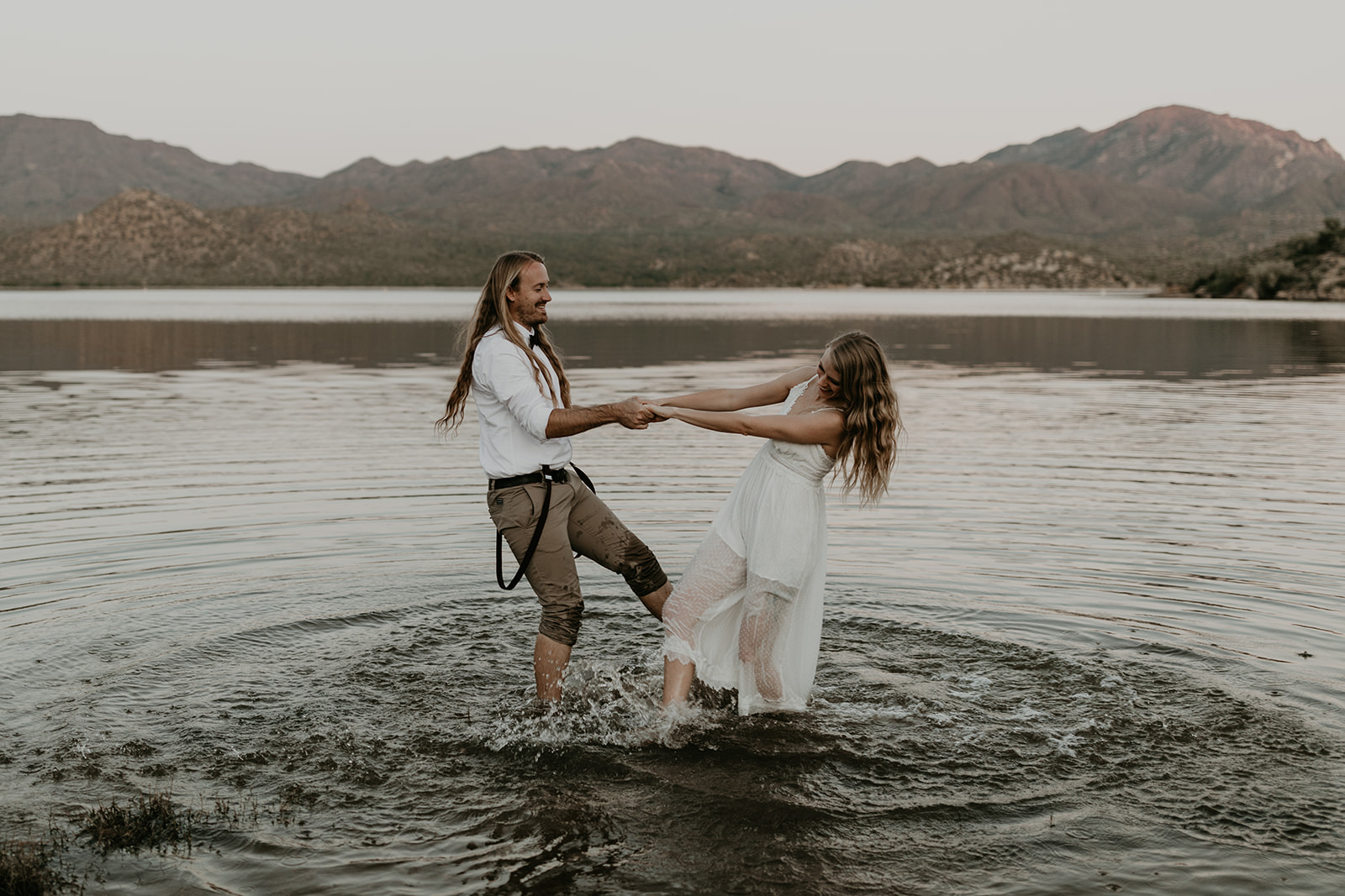 stunning couple play in Bartlett Lake during their Arizona engagement photoshoot