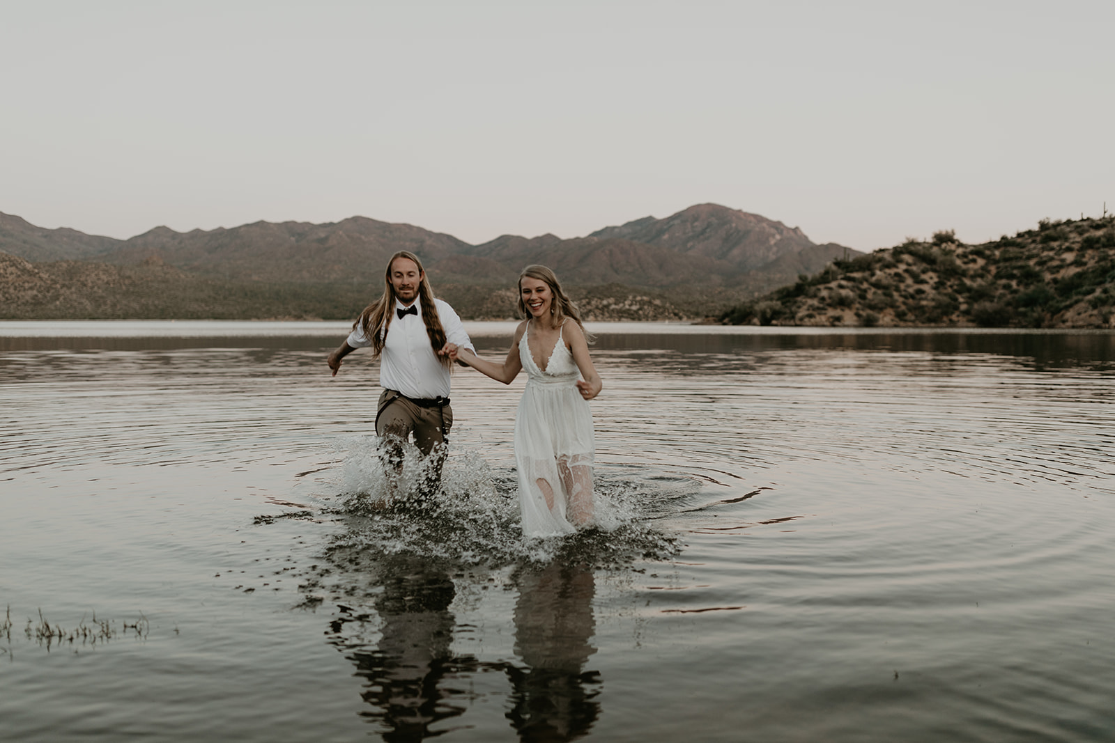 stunning couple play in Bartlett Lake during their Arizona engagement photoshoot