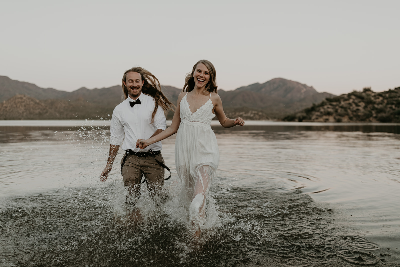 stunning couple play in Bartlett Lake during their Arizona engagement photoshoot