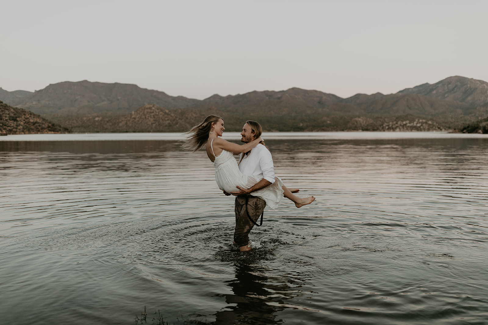 stunning couple play in Bartlett Lake during their Arizona engagement photoshoot