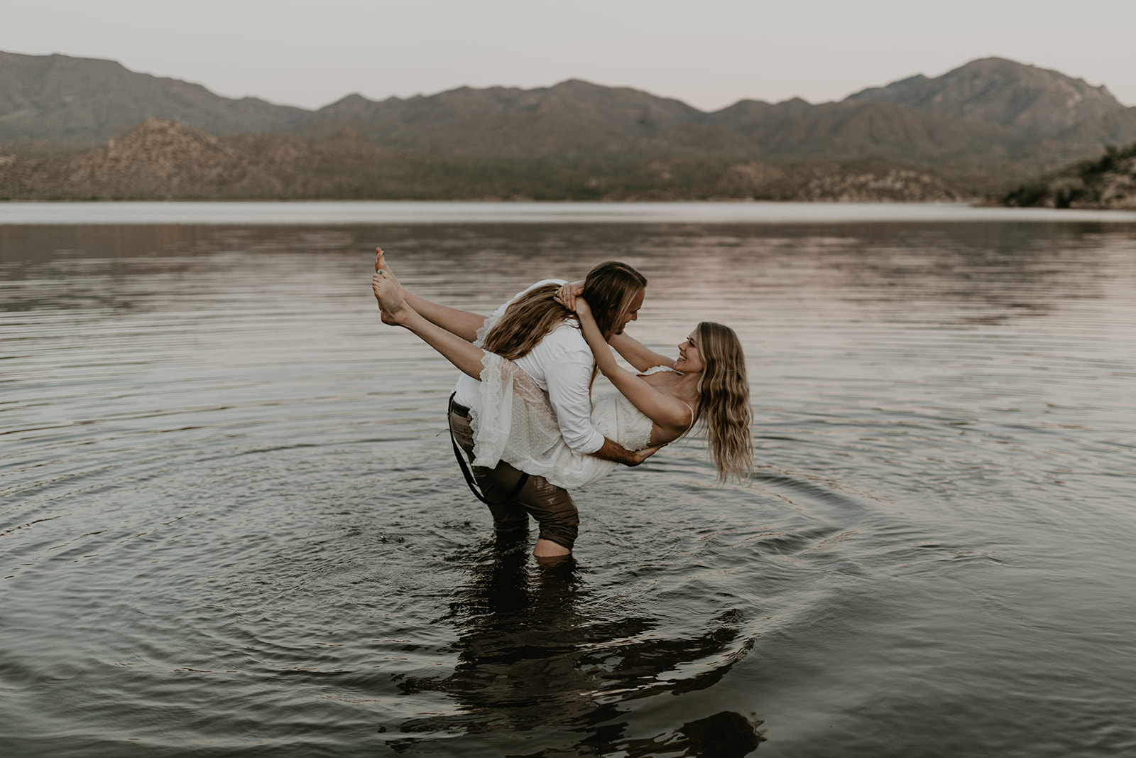 stunning couple play in Bartlett Lake during their Arizona engagement photoshoot