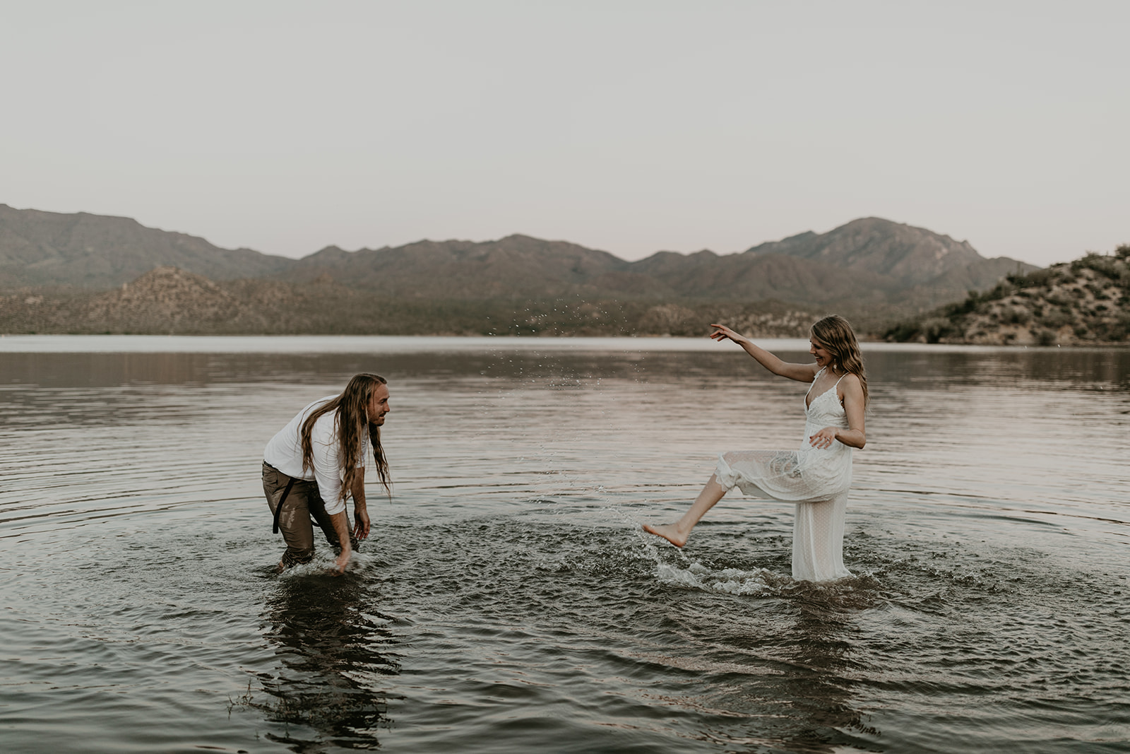 stunning couple play in Bartlett Lake during their Arizona engagement photoshoot