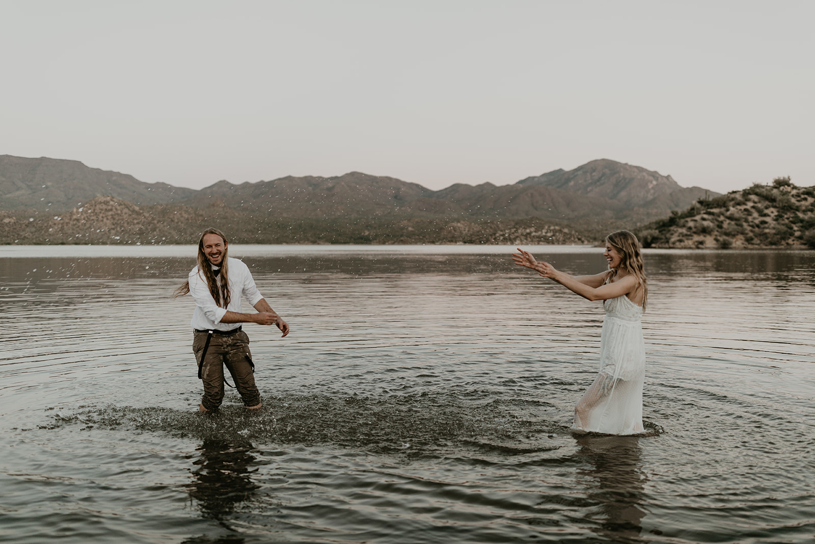 stunning couple play in Bartlett Lake during their Arizona engagement photoshoot