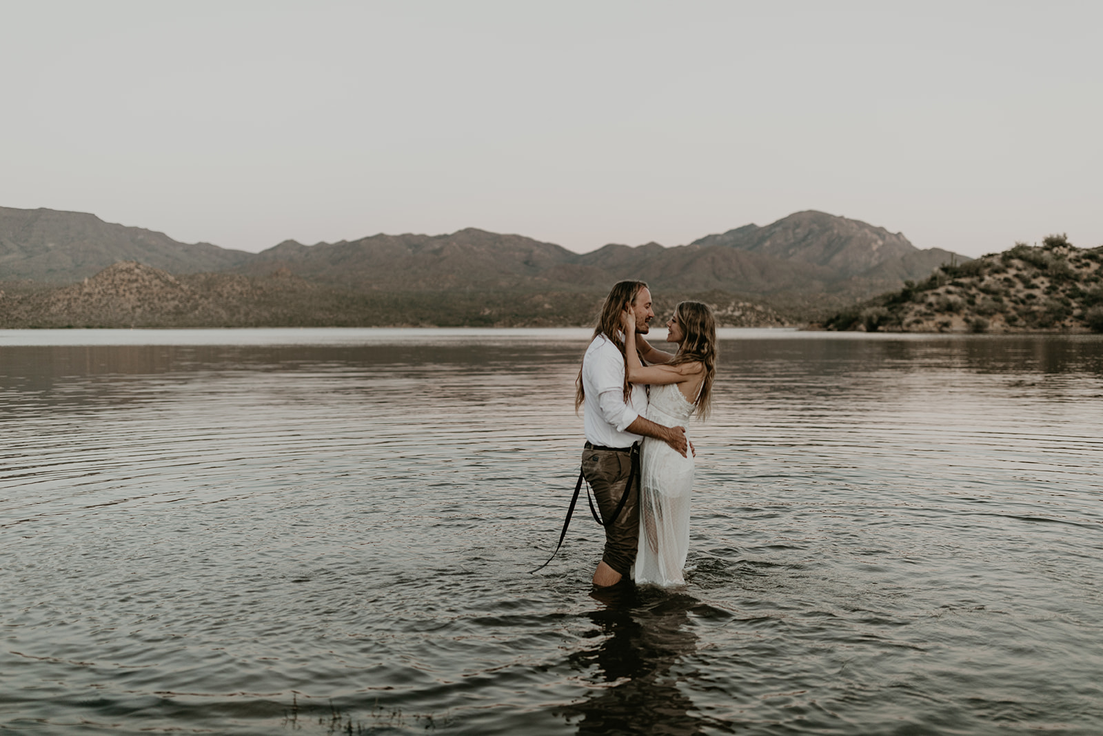 stunning couple play in Bartlett Lake during their Arizona engagement photoshoot