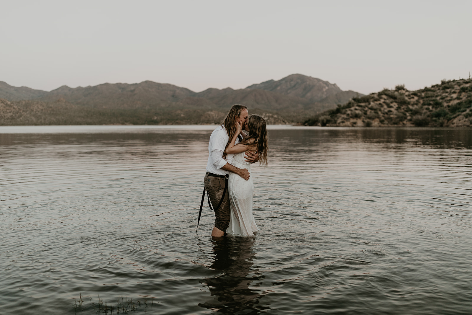 stunning couple play in Bartlett Lake during their Arizona engagement photoshoot