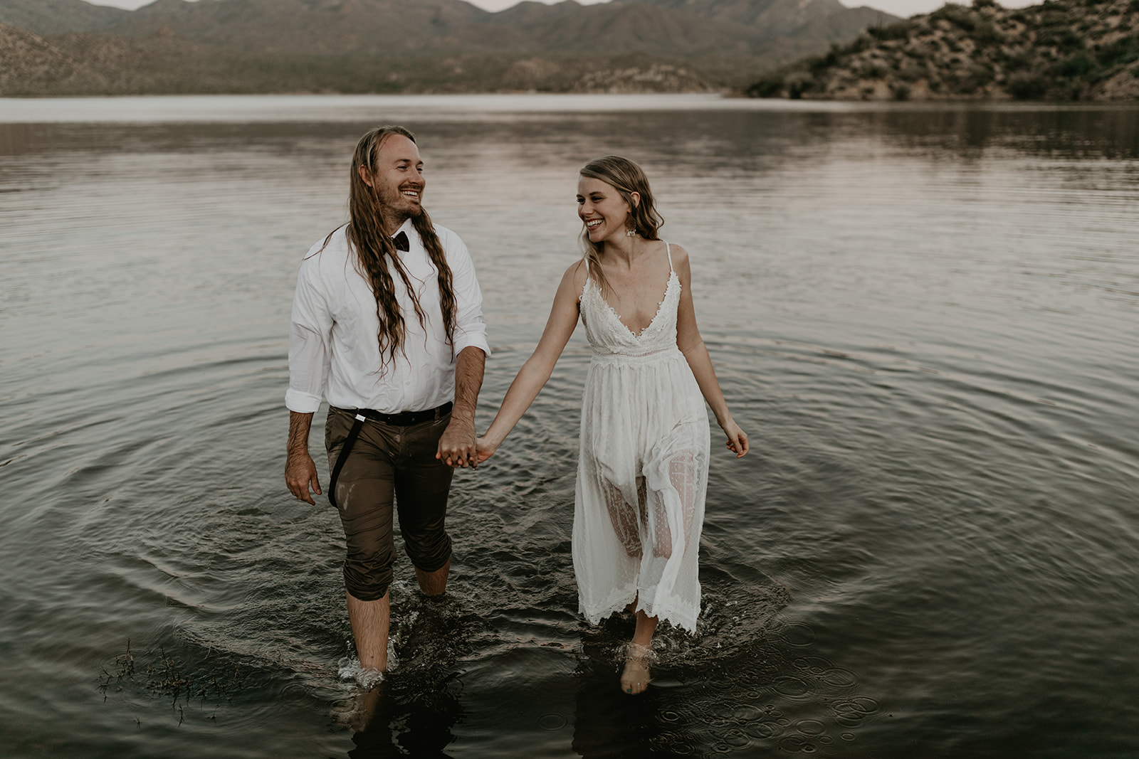 stunning couple play in Bartlett Lake during their Arizona engagement photoshoot