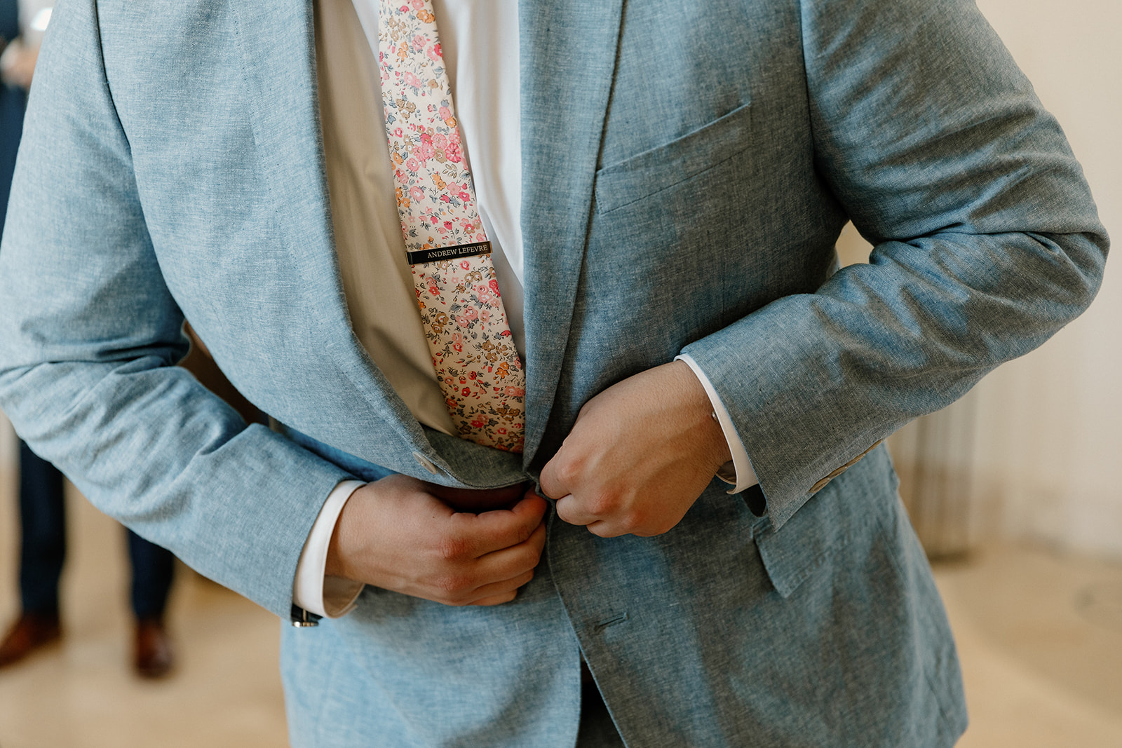 groom adds final touches to his wedding outfit