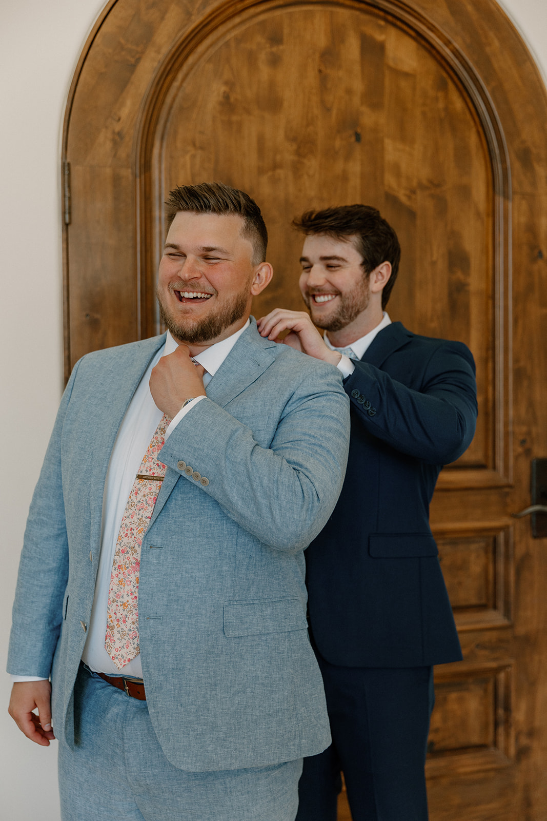 groom adds final touches to his wedding outfit