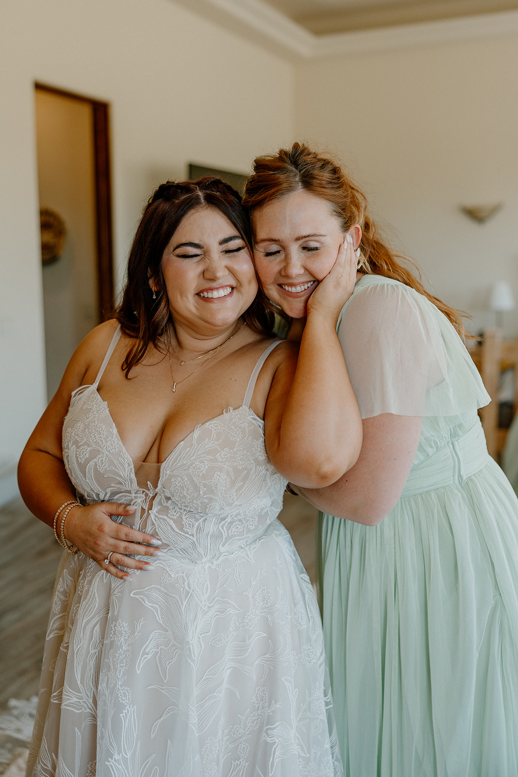 bride embraces a bridesmaid before her dreamy wedding day