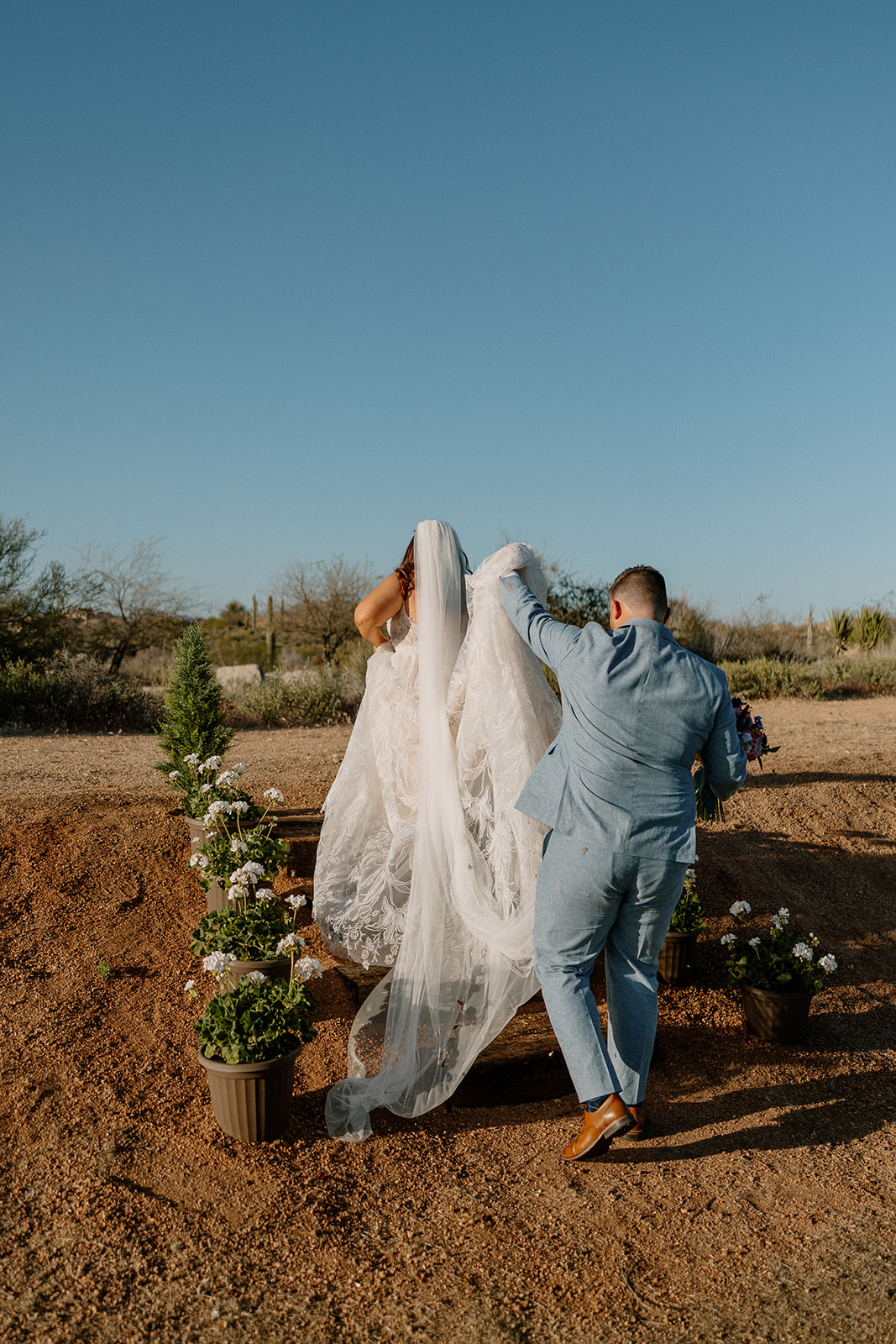 bride and groom walk in the desert together after their dreamy backyard Arizona wedding 