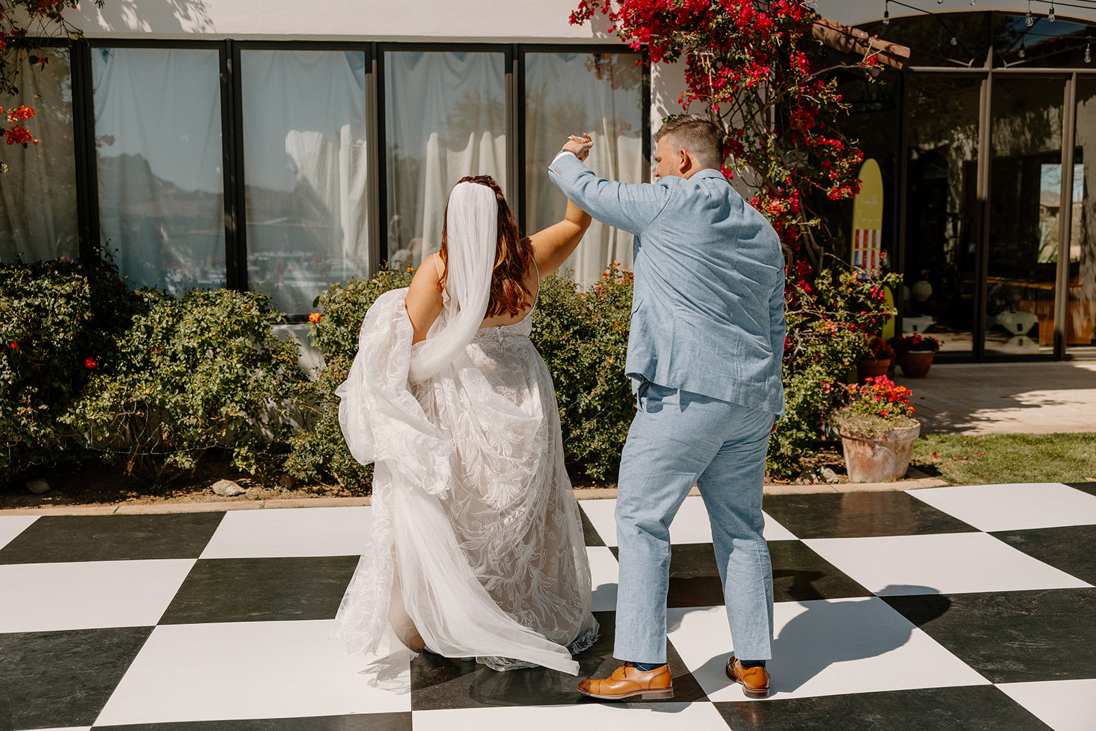 bride and groom share a dance on the checkerboard dance floor