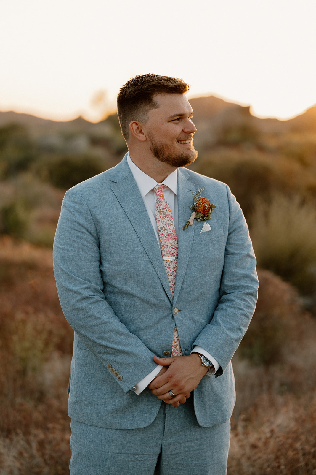 groom poses in the Arizona nature after his dreamy Arizona wedding day