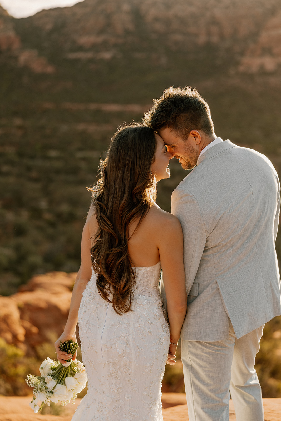 bride and groom pose together in the Arizona desert during their post wedding photoshoot