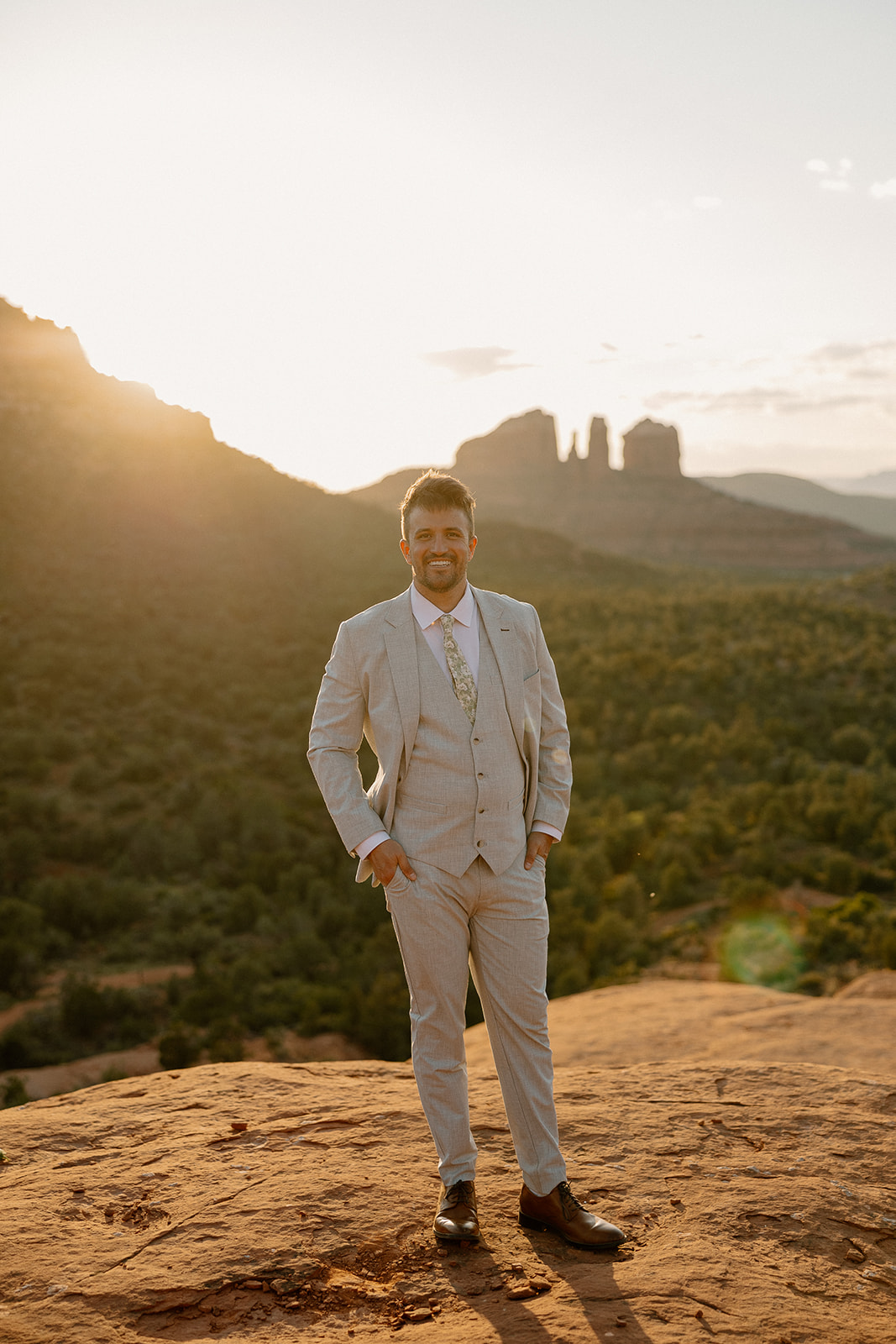 handsome groom poses with the Arizona desert in the background