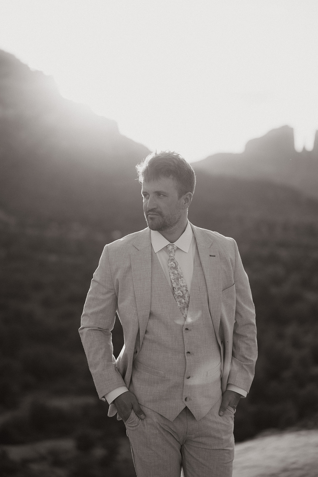 handsome groom poses with the Arizona desert in the background