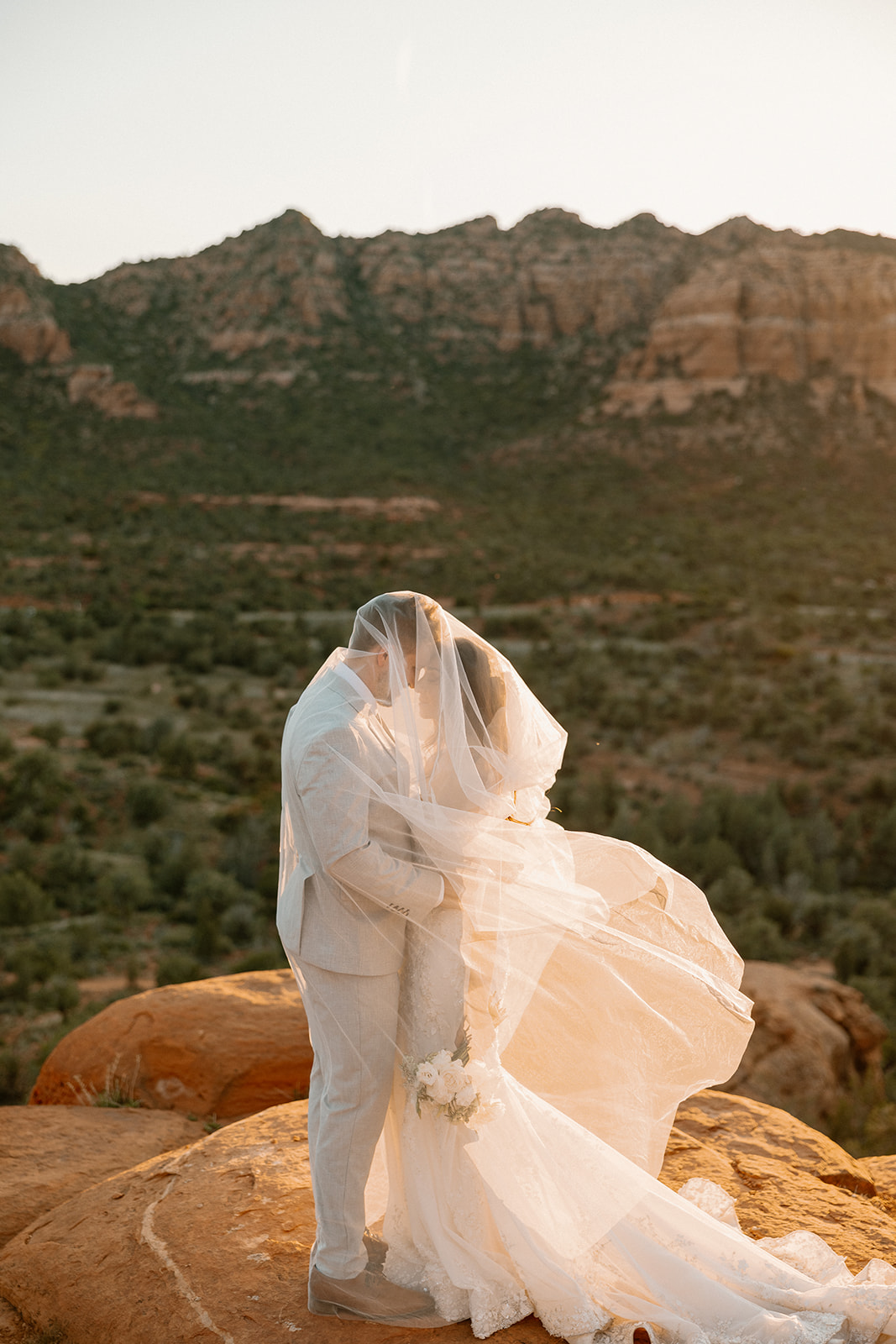 bride and groom pose together in the Arizona desert during their post wedding photoshoot