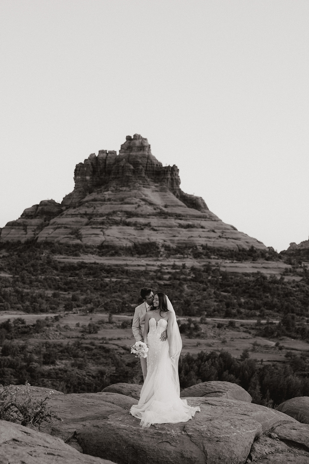 bride and groom pose together in the Arizona desert during their post wedding photoshoot