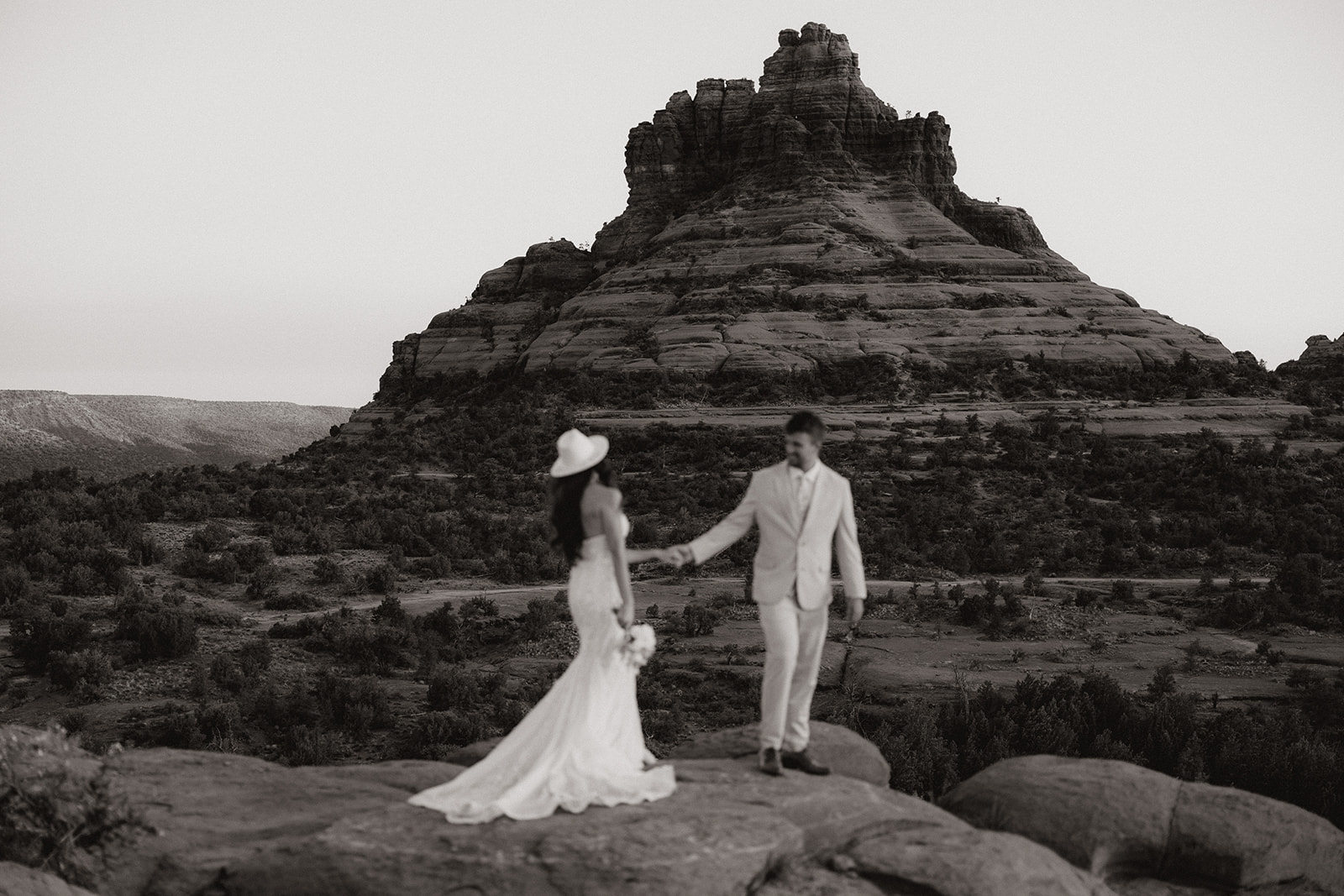 bride and groom pose together in the Arizona desert during their post wedding photoshoot