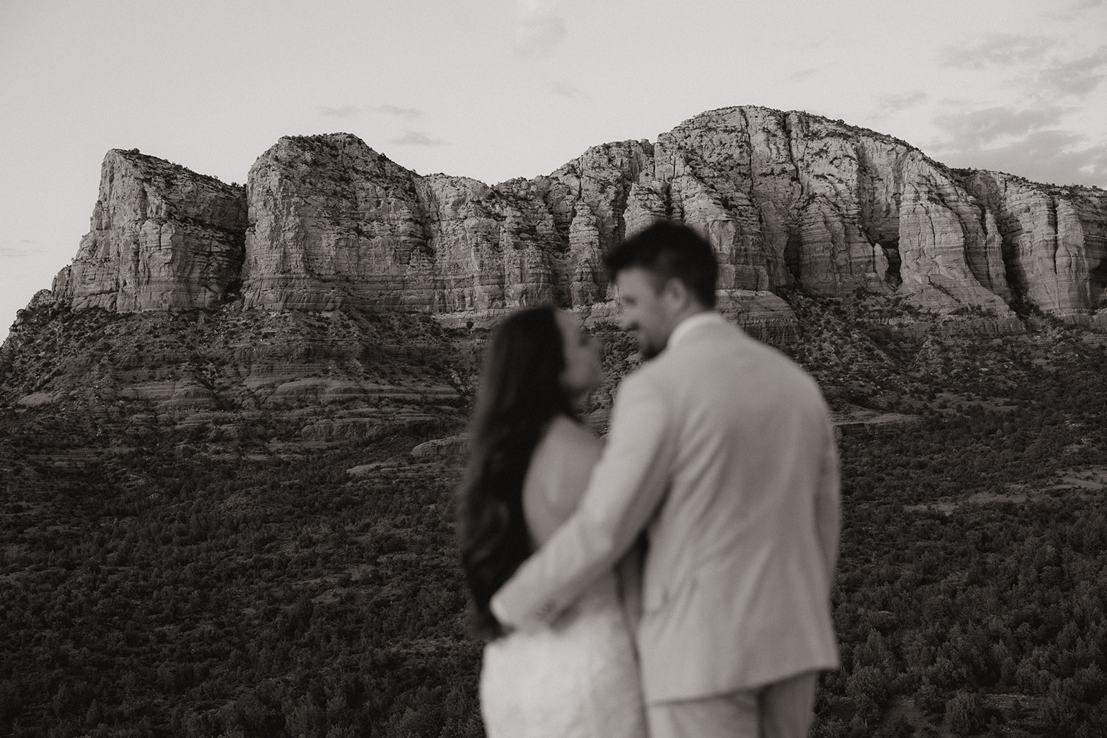 bride and groom pose together in the Arizona desert during their post wedding photoshoot