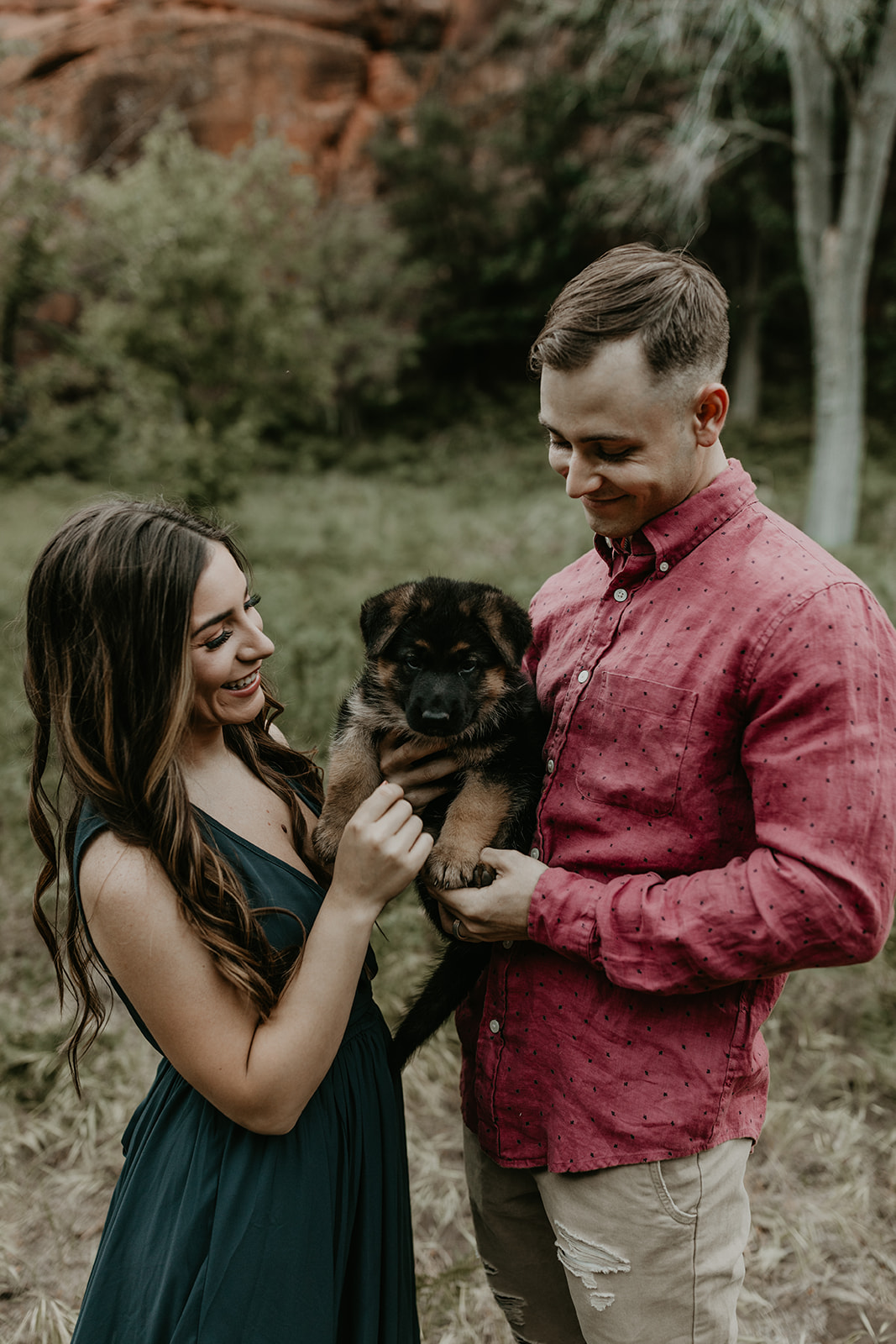 couple pose with their puppy during their Arizona engagement photoshoot